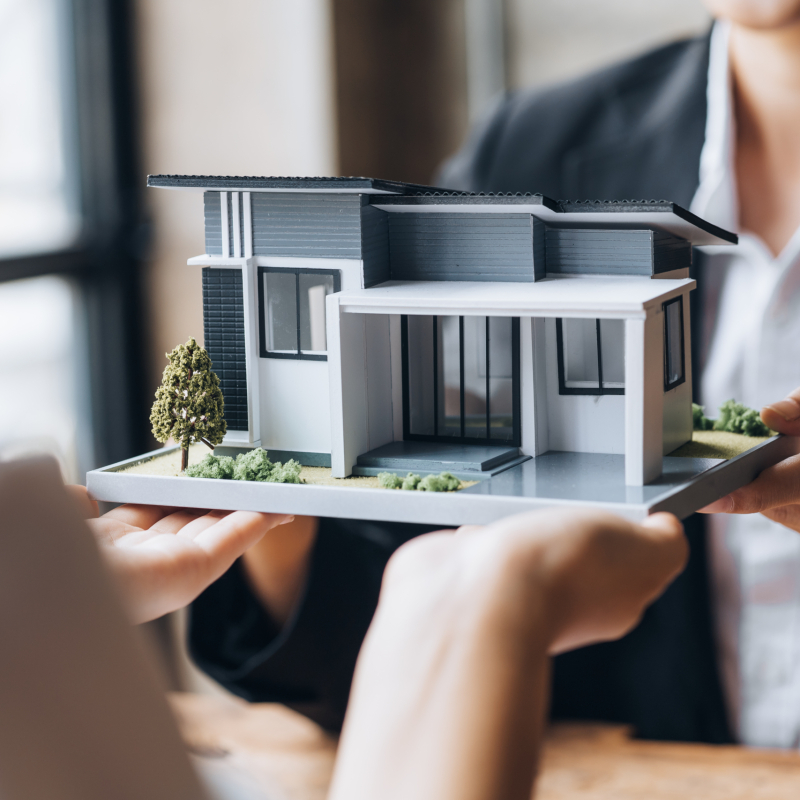 Real estate agents are carrying a housing model of the project to be forwarded to customers as home delivery. Real estate trading ideas and bank loans for buying and selling houses and land.